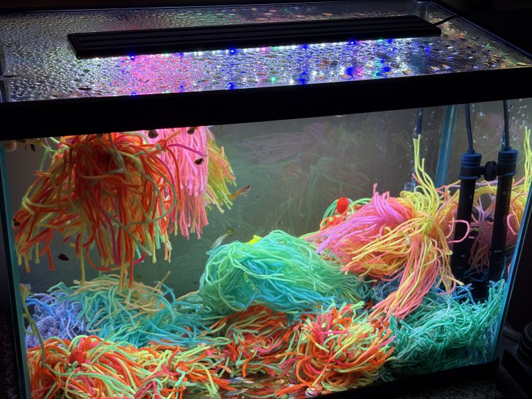 Aquarium with pink, orange and turquoise mops arranged at different heights
